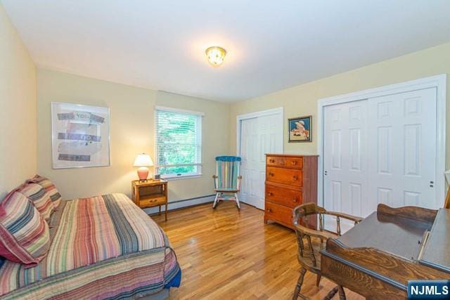 5 Hurley Ct, Wyckoff, NJ 07481 - bedroom with light wood finished floors, multiple closets, and baseboard heating