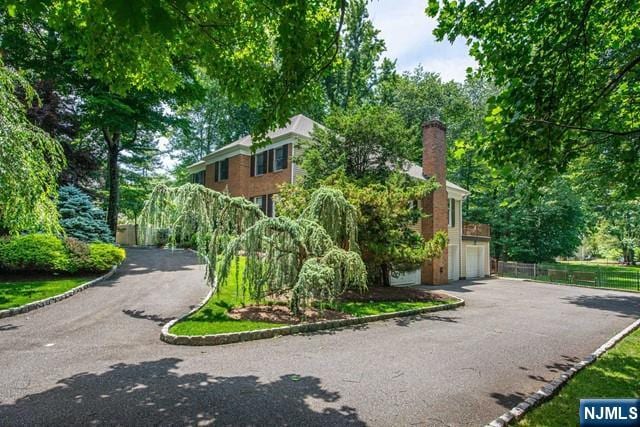 5 Hurley Ct, Wyckoff, NJ 07481 - view of front facade featuring driveway, an attached garage, and a chimney