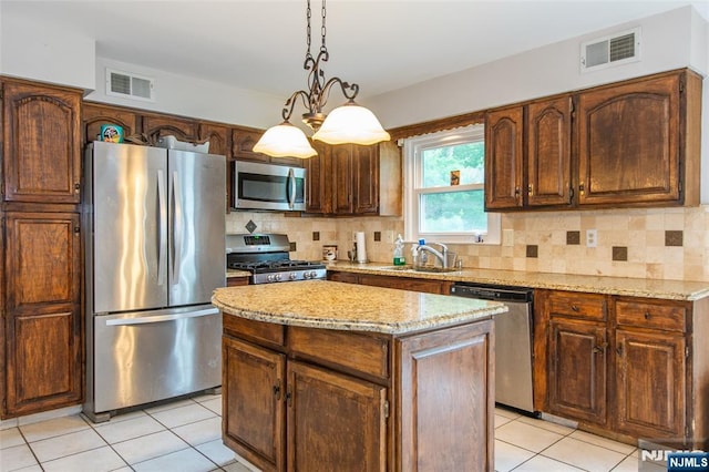 76 Point View Parkway, Wayne, NJ 07470 - kitchen with stainless steel appliances, light tile patterned floors, tasteful backsplash, light stone countertops, and a center island