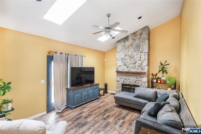 76 Point View Parkway, Wayne, NJ 07470 - living room featuring lofted ceiling, ceiling fan, wood finished floors, a skylight, and a stone fireplace