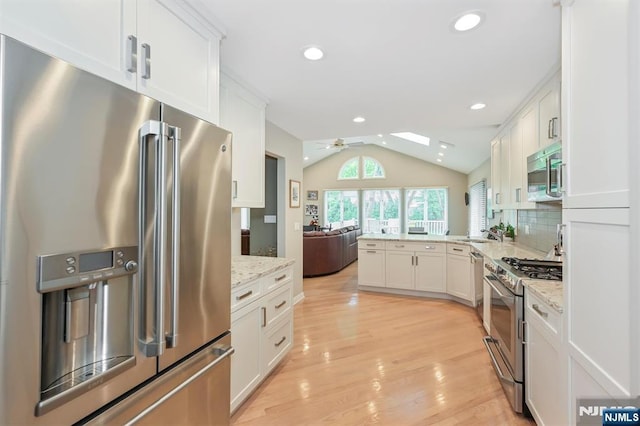 39 Terrace Rd, Wayne, NJ 07470 - kitchen with appliances with stainless steel finishes, vaulted ceiling, open floor plan, a ceiling fan, and white cabinetry