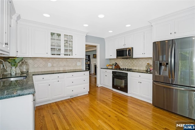 17 Windham Pl, Glen Rock, NJ 07452 - kitchen featuring black appliances, light wood-style flooring, white cabinetry, backsplash, and glass insert cabinets