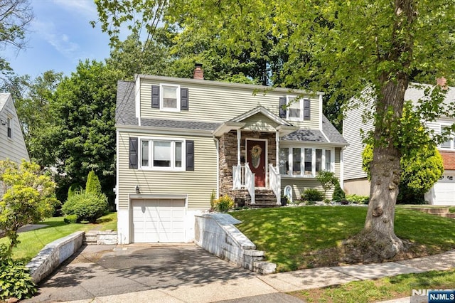 39 Division Ave, Hasbrouck Heights, NJ 07604 - view of front of house with driveway, a front lawn, a shingled roof, and stone siding