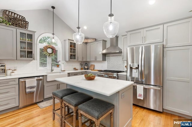 39 Division Ave, Hasbrouck Heights, NJ 07604 - kitchen with stainless steel appliances, wall chimney range hood, gray cabinetry, decorative backsplash, and light wood-type flooring