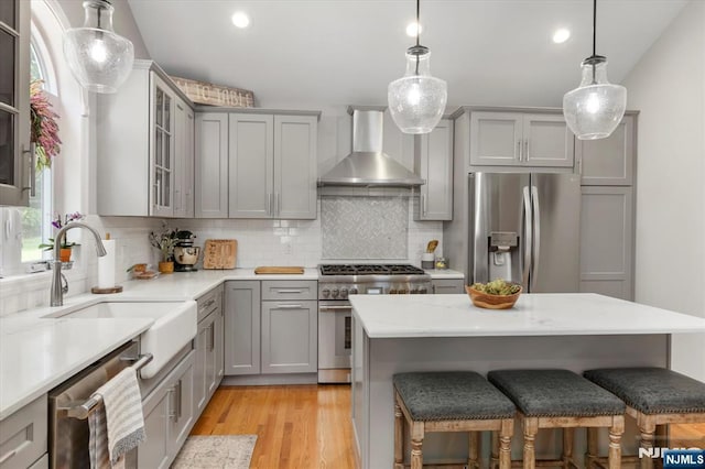 39 Division Ave, Hasbrouck Heights, NJ 07604 - kitchen with stainless steel appliances, gray cabinetry, wall chimney range hood, a kitchen breakfast bar, and decorative backsplash