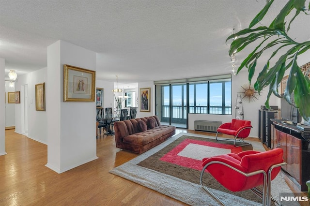 300 Winston Unit 2105, Cliffside Park, NJ 07010 - living room with wood finished floors, a textured ceiling, a fireplace, and a chandelier