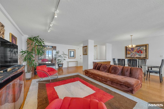 300 Winston Unit 2105, Cliffside Park, NJ 07010 - living room featuring wood finished floors, a textured ceiling, a chandelier, and rail lighting