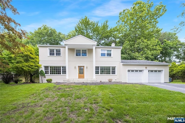 15 Kings Ct, Woodcliff Lake, NJ 07677 - neoclassical / greek revival house with a garage, a front lawn, driveway, and stucco siding