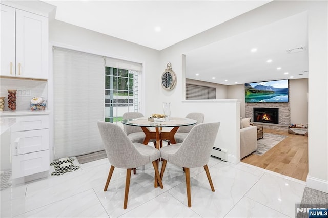 15 Kings Ct, Woodcliff Lake, NJ 07677 - dining space featuring baseboard heating, a glass covered fireplace, recessed lighting, and light marble finish floors