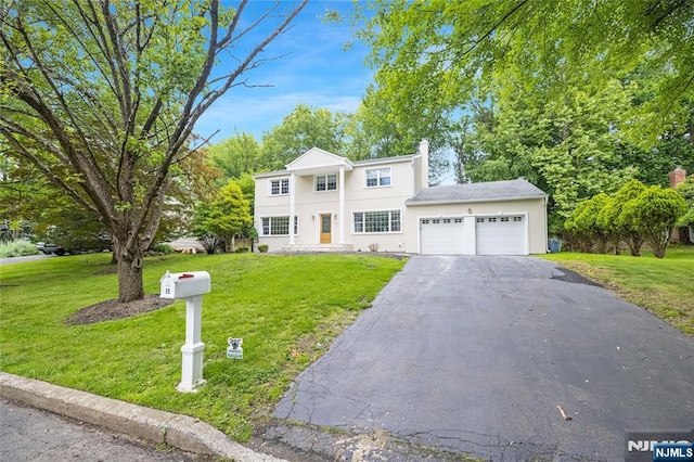 15 Kings Ct, Woodcliff Lake, NJ 07677 - view of front of property with an attached garage, asphalt driveway, a front yard, and stucco siding