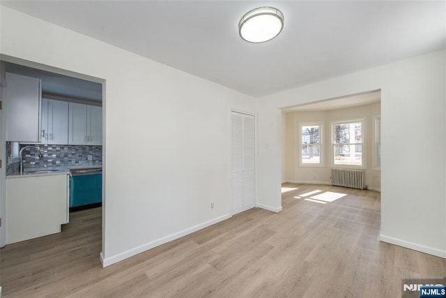 419 Central Ave, Haledon, NJ 07508 - unfurnished living room featuring radiator and light wood-type flooring