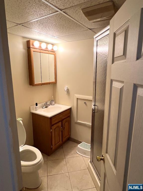 360 Carmita Ave, Rutherford, NJ 07070 - bathroom with vanity, a stall shower, tile patterned floors, and a paneled ceiling