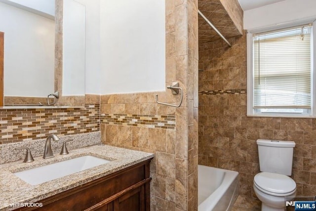 24 Hutton Ave Unit 46, West Orange, NJ 07052 - bathroom featuring tile walls, vanity, healthy amount of natural light, and washtub / shower combination