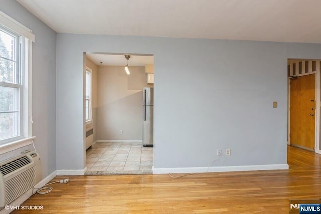 24 Hutton Ave Unit 46, West Orange, NJ 07052 - empty room featuring plenty of natural light, radiator heating unit, and light wood-style flooring