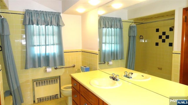 17 Gunther Ave, Lodi, NJ 07644 - bathroom with radiator, vanity, tile walls, shower / tub combo, and wainscoting