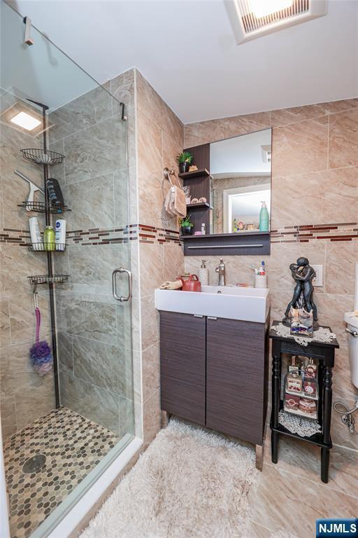 136 Martin Ave, Clifton, NJ 07012 - full bath featuring a stall shower, vanity, and tile walls