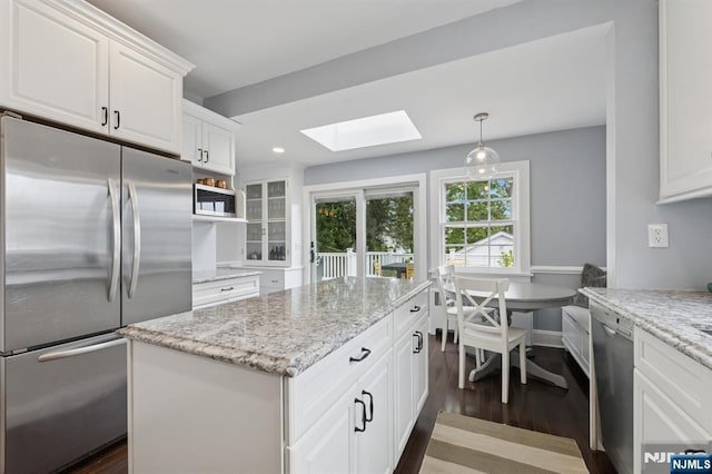 30 Hillcrest Ter, Verona, NJ 07044 - kitchen featuring appliances with stainless steel finishes, a skylight, dark wood-type flooring, white cabinetry, and light stone counters