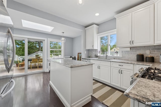 30 Hillcrest Ter, Verona, NJ 07044 - kitchen featuring stainless steel appliances, a skylight, white cabinetry, a center island, and tasteful backsplash