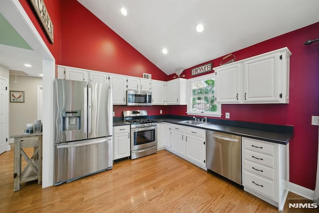 49 Longview Trl, Denville Township, NJ 07834 - kitchen featuring stainless steel appliances, dark countertops, white cabinetry, high vaulted ceiling, and light wood-type flooring