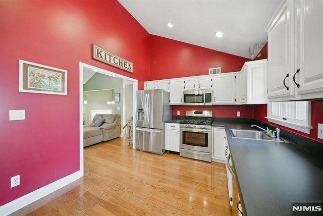 49 Longview Trl, Denville Township, NJ 07834 - kitchen featuring stainless steel appliances, white cabinetry, dark countertops, high vaulted ceiling, and light wood-style floors