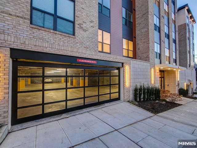 649 38th St Unit 304, Union City, NJ 07087 - doorway to property featuring brick siding, a garage, and driveway
