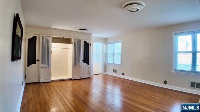 313-321 39th St, Paterson, NJ 07504 - unfurnished bedroom featuring wood finished floors and multiple windows