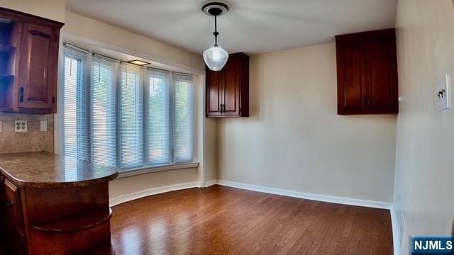 313-321 39th St, Paterson, NJ 07504 - unfurnished dining area featuring dark wood-style floors and baseboards