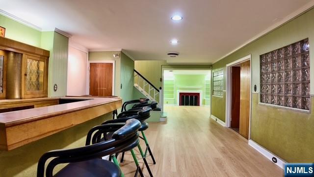 313-321 39th St, Paterson, NJ 07504 - bar featuring ornamental molding, wood finished floors, stairs, and recessed lighting