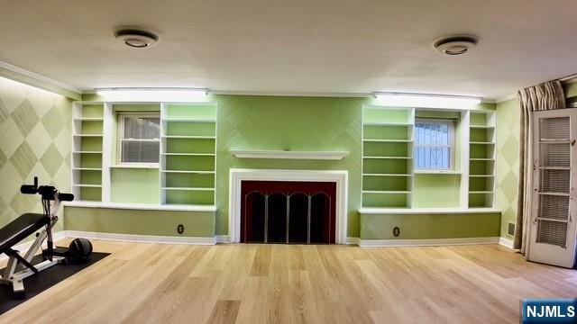 313-321 39th St, Paterson, NJ 07504 - unfurnished living room with wood finished floors, a fireplace, ornamental molding, built in shelves, and wallpapered walls