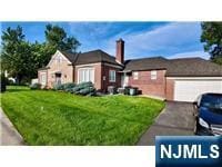 313-321 39th St, Paterson, NJ 07504 - view of front of house with a front yard, a garage, and asphalt driveway