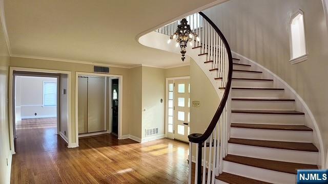 313-321 39th St, Paterson, NJ 07504 - stairway featuring ornamental molding, wood finished floors, elevator, and a chandelier