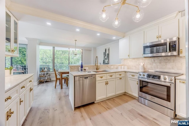 1 Claridge Dr Unit 418, Verona, NJ 07044 - kitchen with appliances with stainless steel finishes, ornamental molding, tasteful backsplash, white cabinetry, and a peninsula