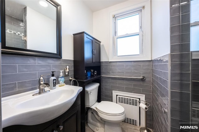 71 Pickens St, Little Ferry, NJ 07643 - bathroom with tile walls, radiator heating unit, vanity, wainscoting, and tile patterned floors