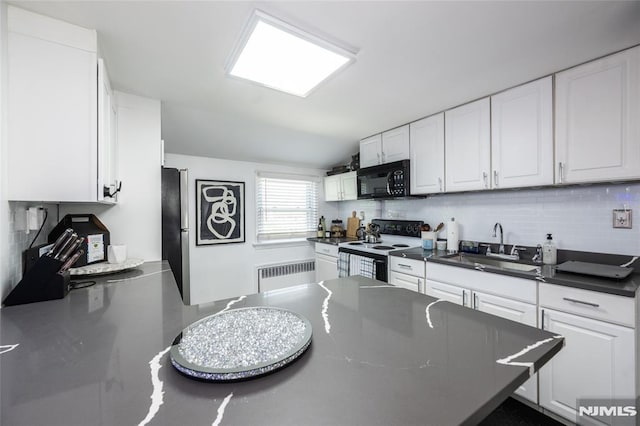 71 Pickens St, Little Ferry, NJ 07643 - kitchen featuring white range with electric stovetop, radiator heating unit, black microwave, freestanding refrigerator, and dark countertops