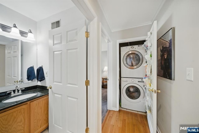 92 Maple Ln Unit 3021, Mount Arlington Boro, NJ 07856 - washroom with stacked washer / dryer, light wood-type flooring, and ornamental molding