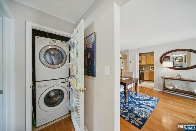 92 Maple Ln Unit 3021, Mount Arlington Boro, NJ 07856 - washroom with estacked washer and dryer, crown molding, and light wood-style floors