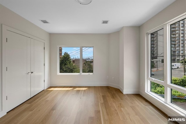 135 Old Palisade Rd, Fort Lee, NJ 07024 - unfurnished bedroom with multiple windows and light wood-type flooring