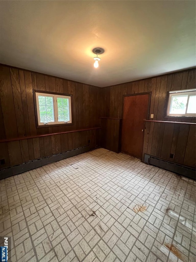 106 Prescott St, Demarest, NJ 07627 - unfurnished room featuring a baseboard radiator, brick patterned flooring, and wooden walls
