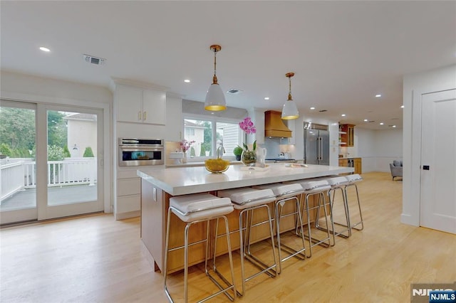 415 Bailey Rd, Paramus, NJ 07652 - kitchen featuring appliances with stainless steel finishes, custom range hood, light wood finished floors, light countertops, and recessed lighting