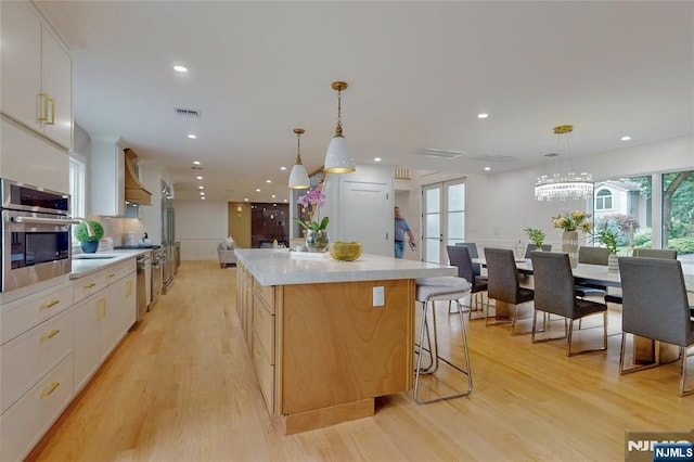 415 Bailey Rd, Paramus, NJ 07652 - kitchen with stainless steel appliances, premium range hood, light wood finished floors, light countertops, and a kitchen island