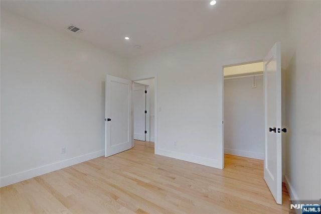 415 Bailey Rd, Paramus, NJ 07652 - unfurnished bedroom with light wood-style floors, recessed lighting, a walk in closet, and a closet