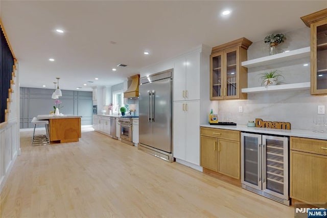 415 Bailey Rd, Paramus, NJ 07652 - kitchen with wine cooler, high quality appliances, wall chimney range hood, light wood-type flooring, and light countertops