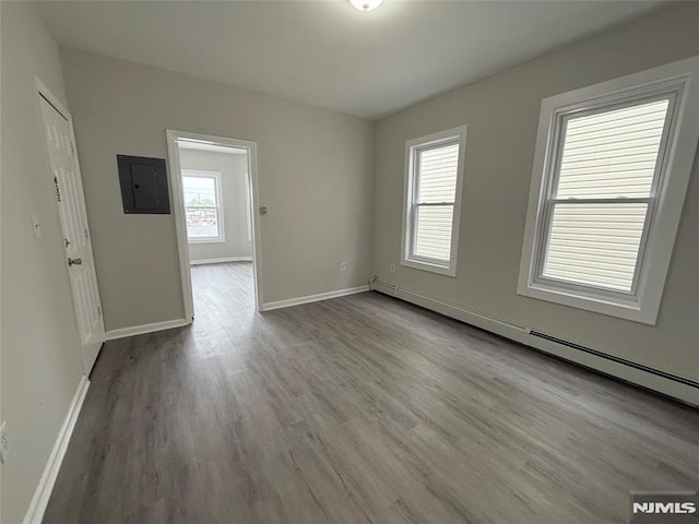 1 9th Ave, East Orange, NJ 07018 - unfurnished room featuring electric panel, a baseboard radiator, and wood finished floors