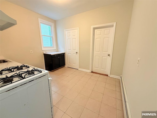 1 9th Ave, East Orange, NJ 07018 - kitchen featuring white gas range, wall chimney range hood, a baseboard heating unit, light tile patterned floors, and light countertops