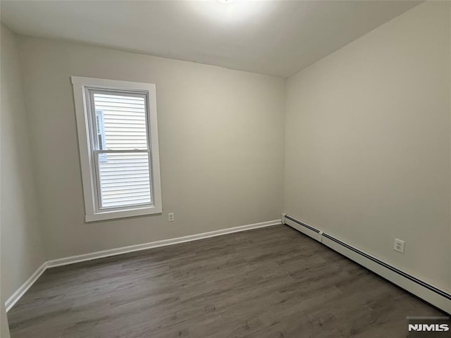 1 9th Ave, East Orange, NJ 07018 - empty room with a baseboard radiator and dark wood-type flooring