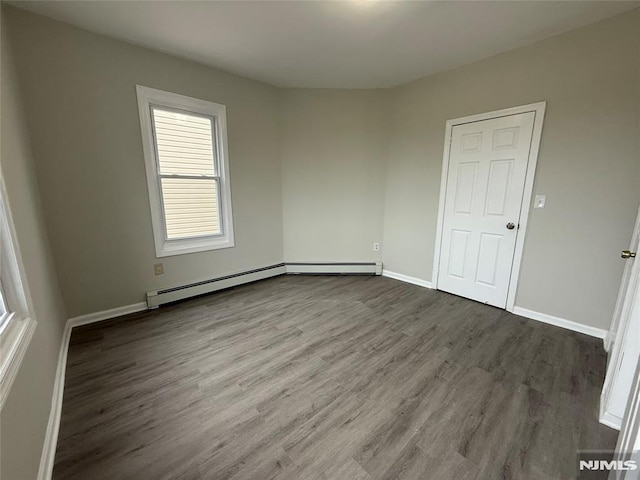 1 9th Ave, East Orange, NJ 07018 - unfurnished room with wood finished floors and a baseboard heating unit