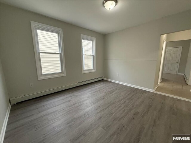 1 9th Ave, East Orange, NJ 07018 - spare room with baseboard heating and wood finished floors