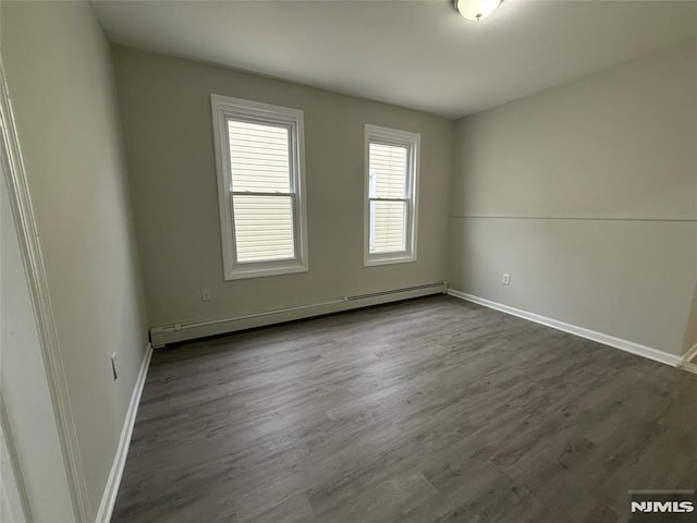 1 9th Ave, East Orange, NJ 07018 - empty room featuring a baseboard heating unit and dark wood-style floors