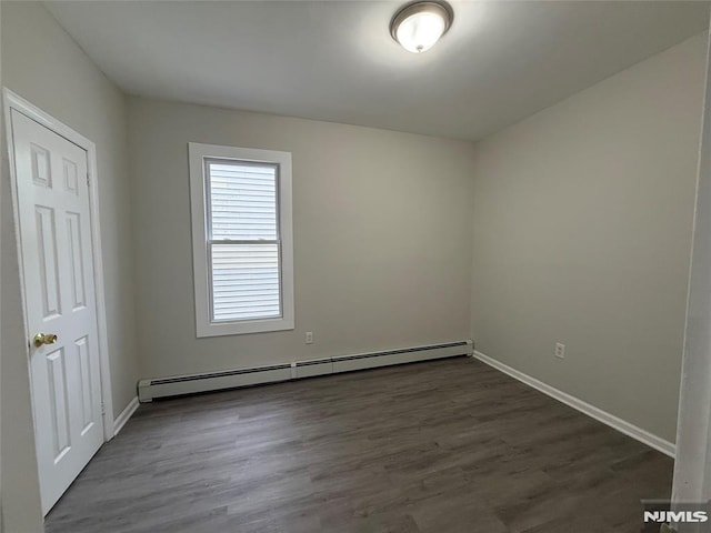 1 9th Ave, East Orange, NJ 07018 - empty room featuring a baseboard radiator and dark wood-style floors