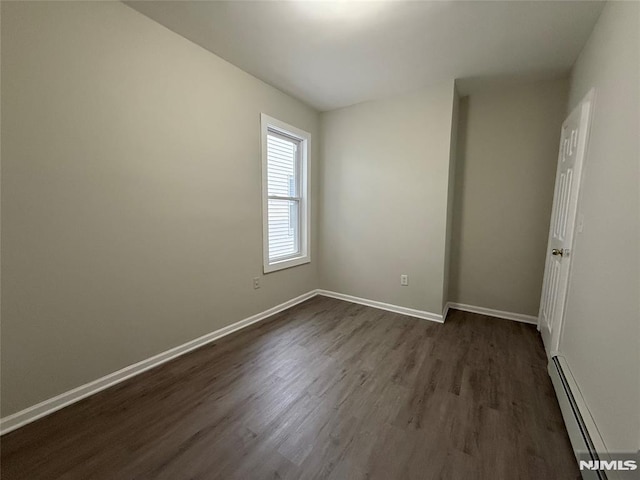 1 9th Ave, East Orange, NJ 07018 - unfurnished room featuring a baseboard heating unit and dark wood-style flooring